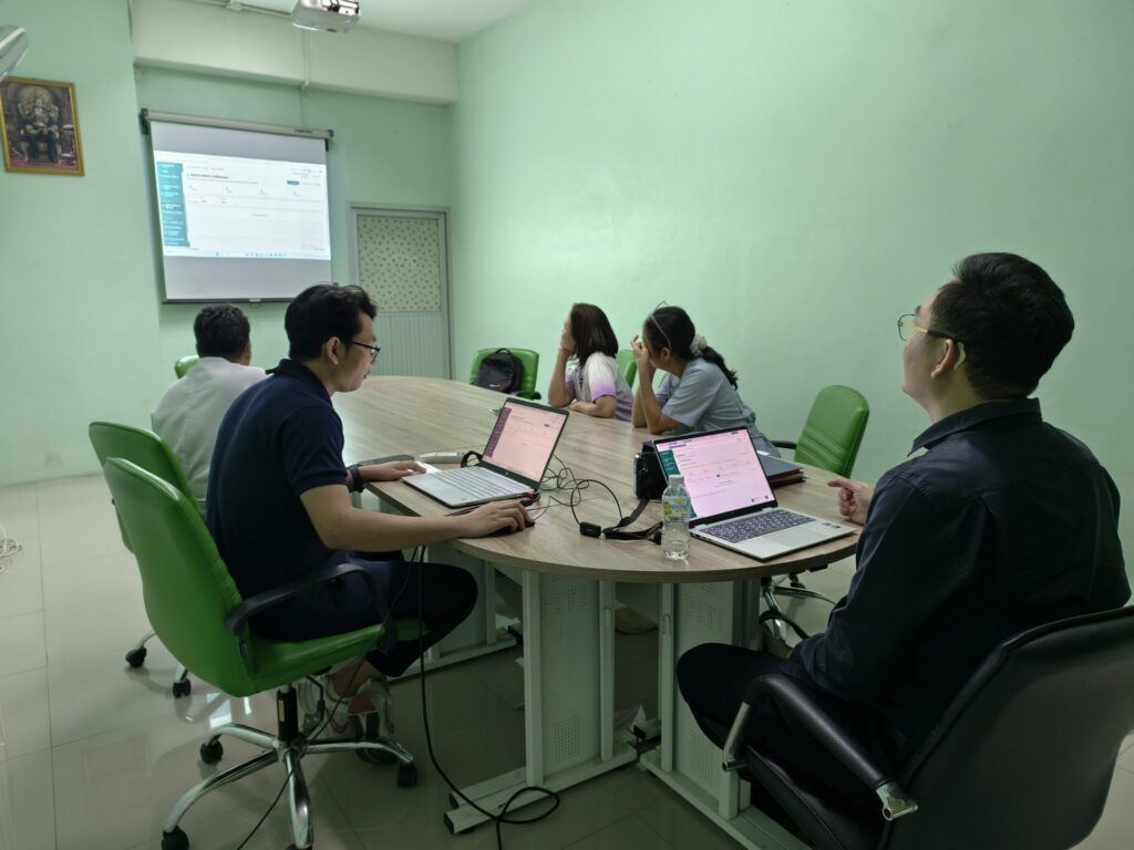 พยาบาลจิตเวชและทีมงานดูหน้าจอ Smart TeLeMind ที่ฉายระหว่างการประชุมทบทวนระบบในโรงพยาบาล